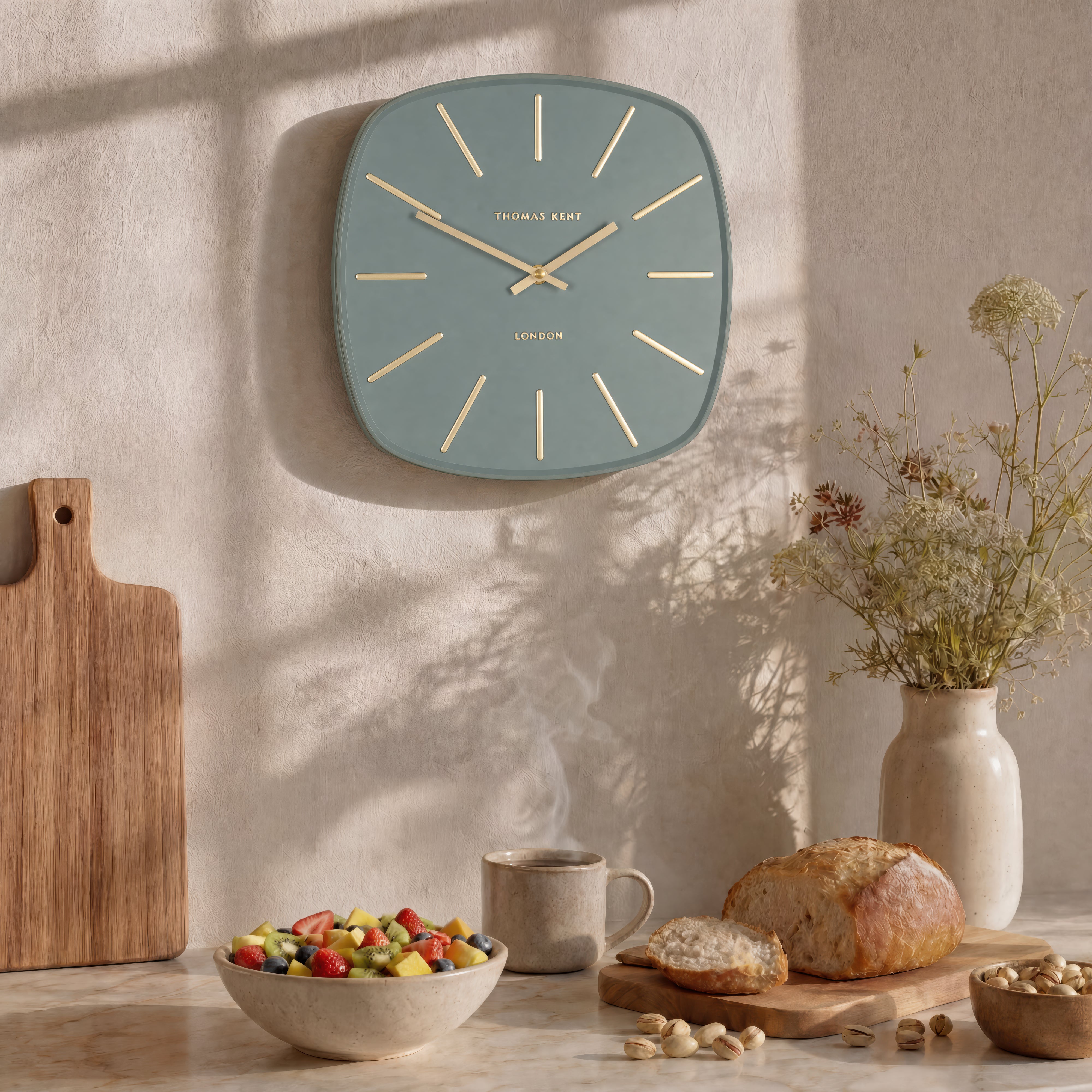 Wall clock on a wall with a table below displaying food and decor items.
