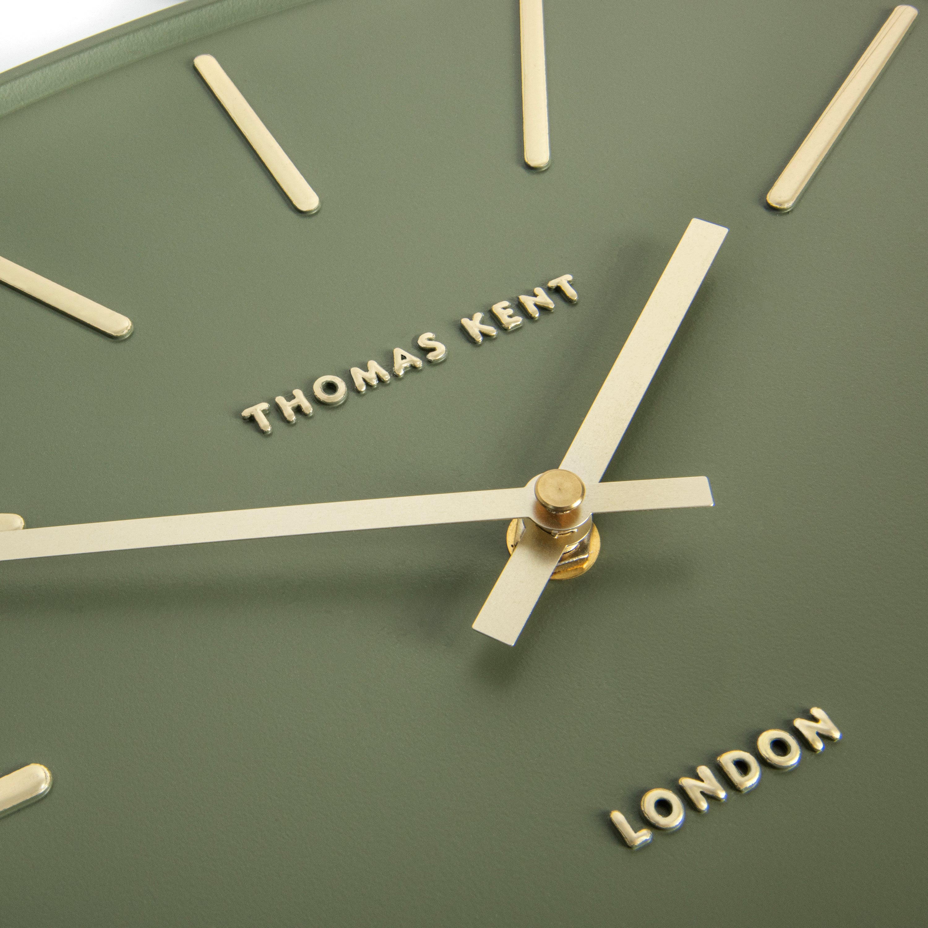 Close-up of a clock face with 'Thomas Kent' and 'London' text on a green background